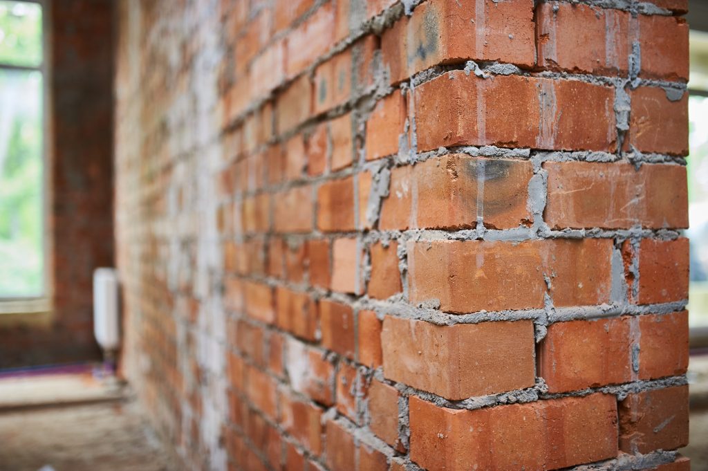 Building, construction site in progress to new house, brick wall in the room