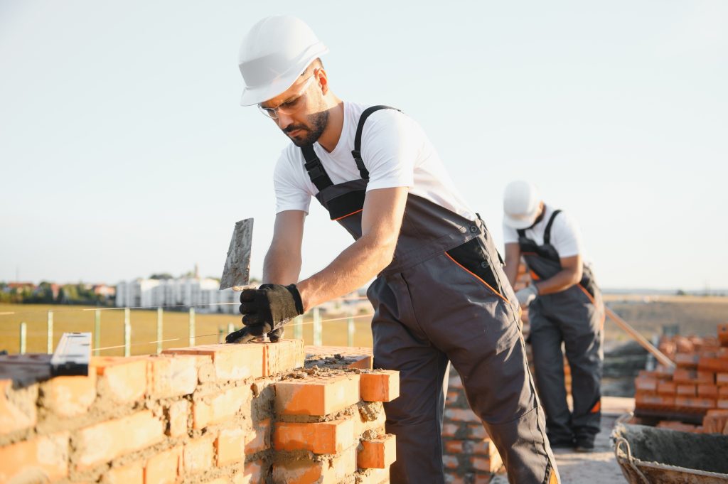 Professional construction workers build a brick house.