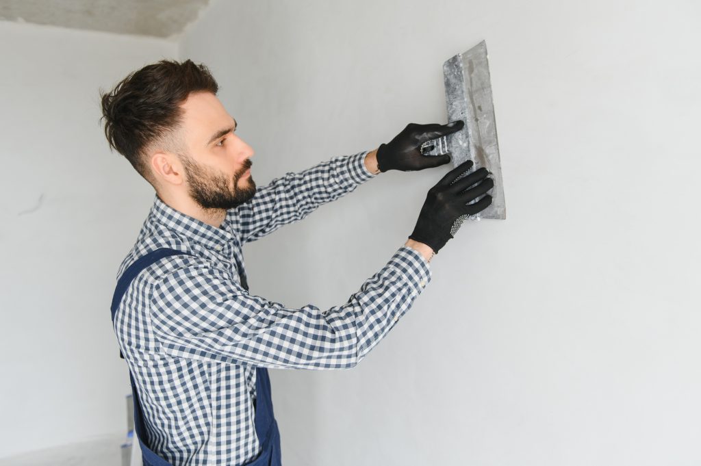 Young worker making repair in room